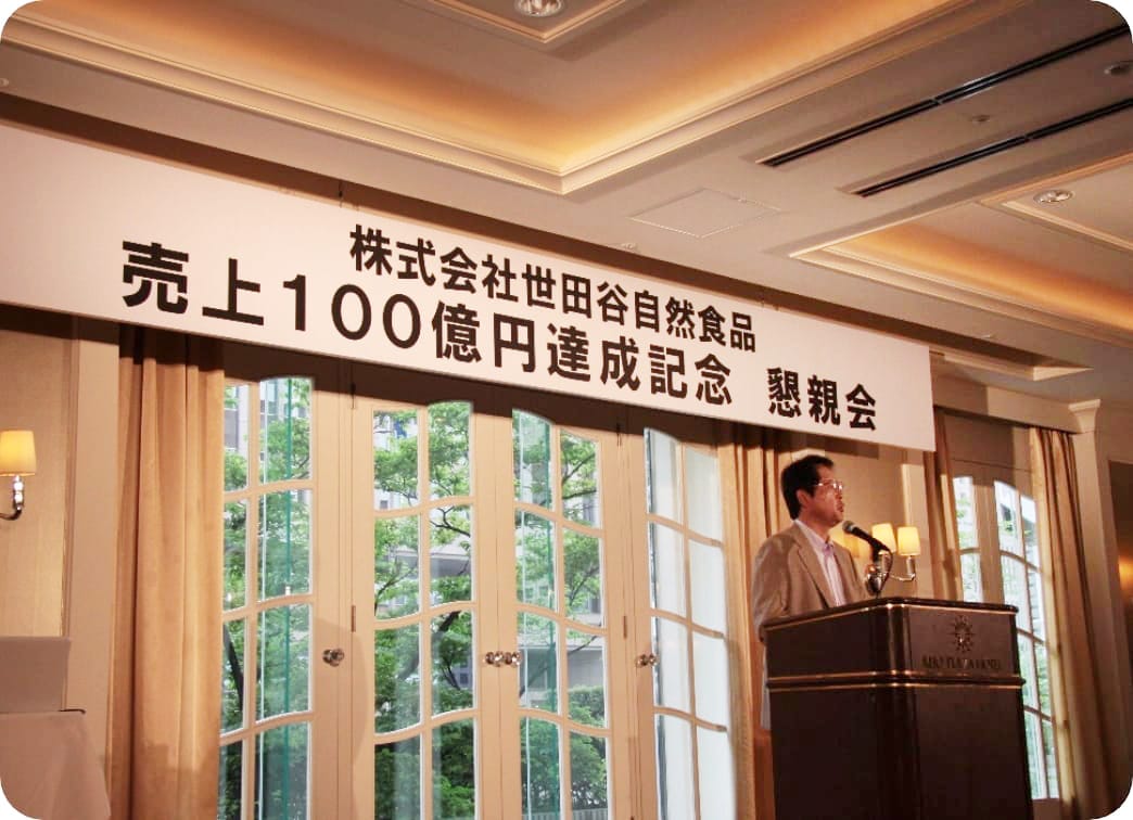 世田谷自然食品売上100億円達成記念懇親会でスピーチする河西社長